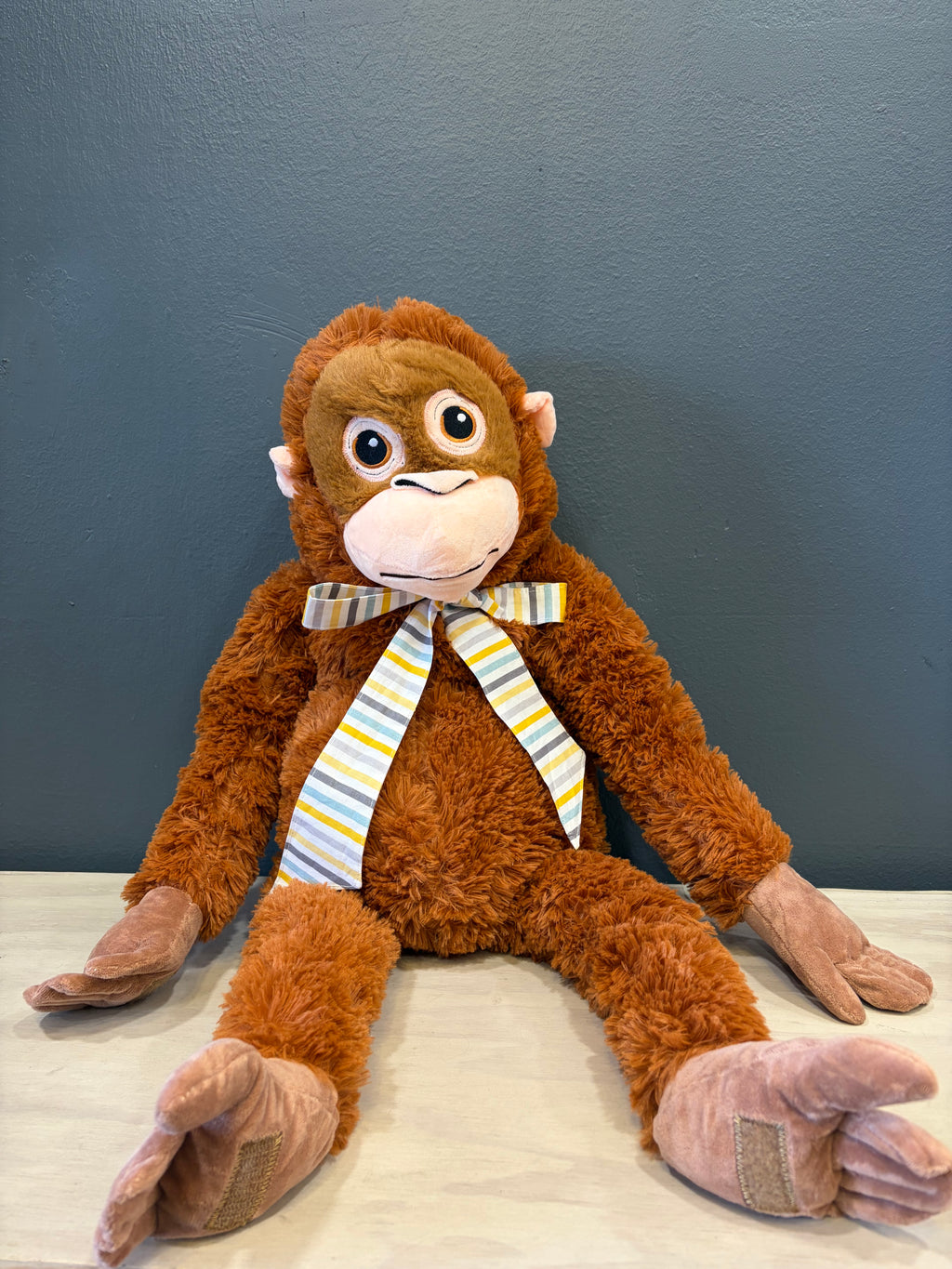 Peluche mono XL con cinta a rayas de colores