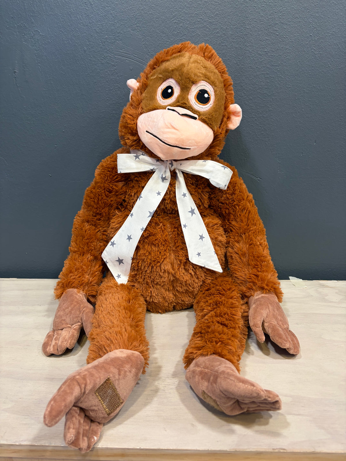 Peluche mono XL sentado con cinta blanca de estrellas grises
