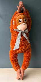 Peluche mono XL colgado de sus brazos largos