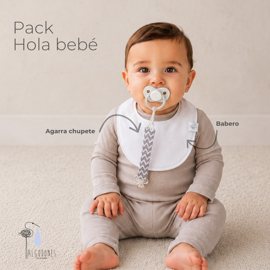 Pack Hola Bebé: el babero y el agarra chupete señalados sobre la guagua