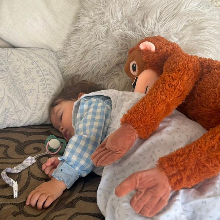 Bebé durmiendo abrazado al peluche mono XL